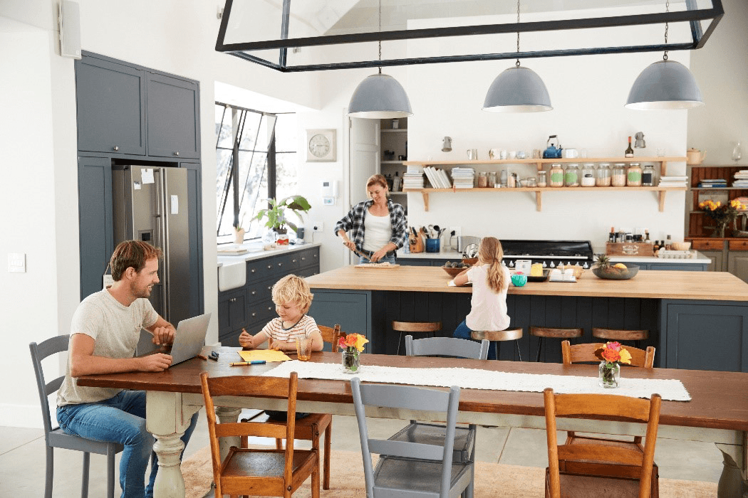 A family gathers around a table in a cozy kitchen, sharing a meal and enjoying each other's company.