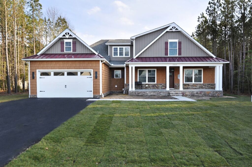 A house featuring a driveway leading to a garage, surrounded by a well-maintained lawn.