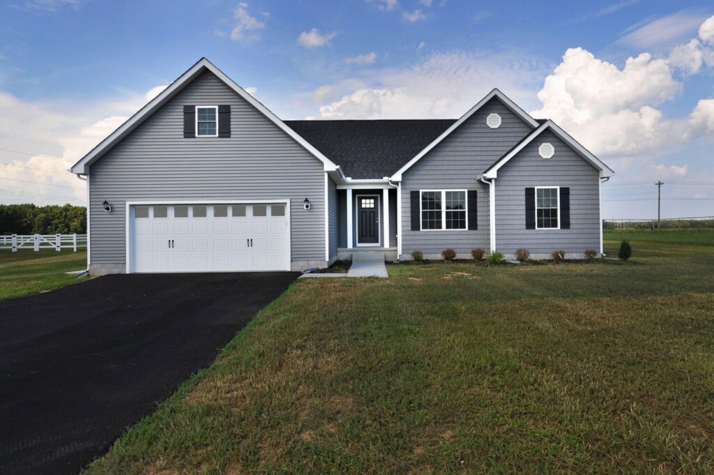 A gray house featuring a driveway and an attached garage.