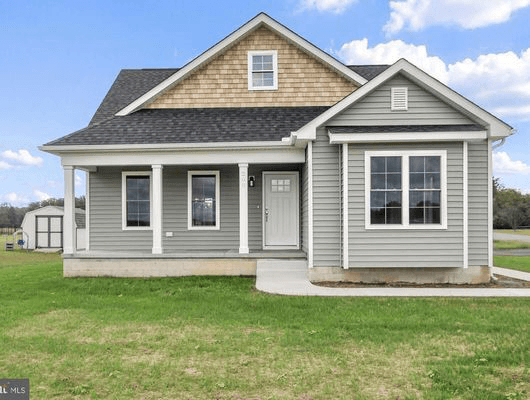 Gray house with a front porch and a well-kept front yard, surrounded by greenery.