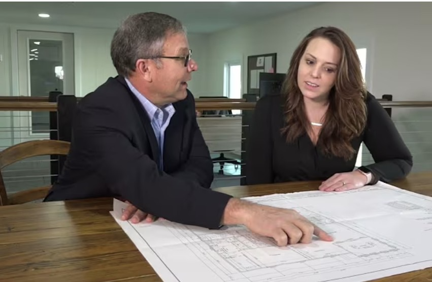 Custom home builder reviewing floor plan options with a homeowner.
