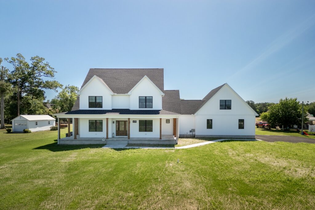 Newly constructed modern house on a green lot showcasing the benefits of a land home package.